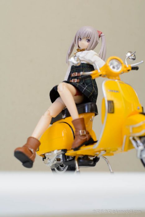 イノセンティアがベスパのシートに座っている様子をローアングルで